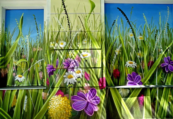 Bemalte Häuserwand mit Blumenwiesen