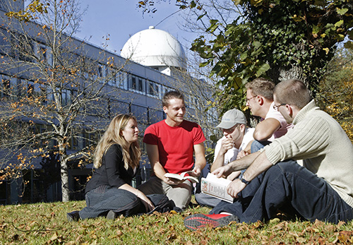 Studenten sitzen auf der Campus-Wiese der Universität der Bundeswehr München