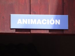 Ein blaues Schild an einer roten Holzwand mit der Aufschrift: Animacion.