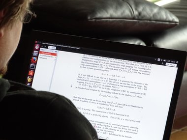 Ein Student schaut auf seinen Computerbildschirm aufdem mathematische Inhalte zu sehen sind.
