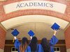 Drei Frauen halten vor ihrer Universität ihren Doktorhut hoch und freuen sich über ihren akademischen Abschluss.