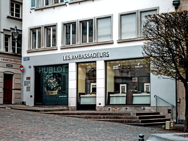 Werbung im Schaufenster in einem Uhrengeschäft für Armbanduhren der Marken Hublot und Mont Blanc.