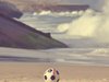 Ein Fußball liegt am Strand.