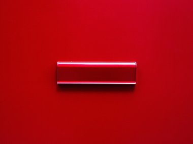 Ein roter Briefschlitz an einer roten Tür.