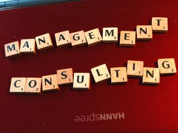 Scrabble-Buchstaben bilden die Worte Management Consulting.