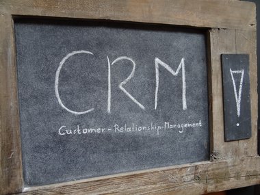 CRM-Software: Auf einer kleinen Tafel stehen mit Kreide die Buchstaben CRM: Customer-Relationship-Management geschrieben.