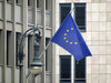 Europa-Glossar: Eine Europaflagge vor einem Betongebäude und eine verschnörkelte Straßenlampe.