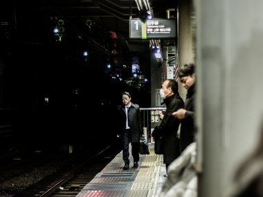 Japanischer Geschäftsmann im Anzug in der U-Bahn in Tokio.