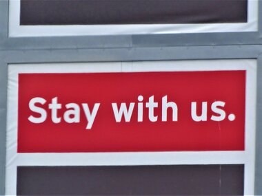 Kundenbindung: Ein rotes Schild mit den Worten: "Stay with us".