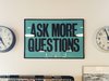 Ein grünes Schild mit der Aufschrift: Ask more questions.