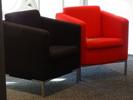 Möbel: Zwei Sessel in schwarz und in rot stehen nebeneinander.