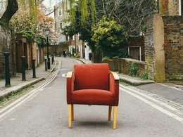 Ein roter Sessel mitten auf einer Straße.