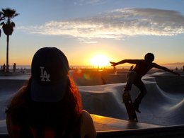 Ein Junge mit seinem Skateboard bei Sonnenuntergang.