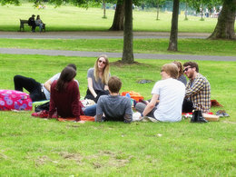 Studentenleben im Studium: Eine Gruppe Studenten sitzen im Park auf einer Wiese.