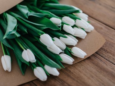 Weiße Tulpen in einer Papiertüte.