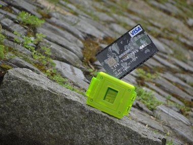 Eine Visakarte in einem neongrünen Speicher auf einem Steinboden.