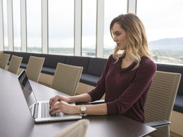 Weiterbildungen für Kaufleute: Eine Frau sitzt im Büro an einem Laptop.