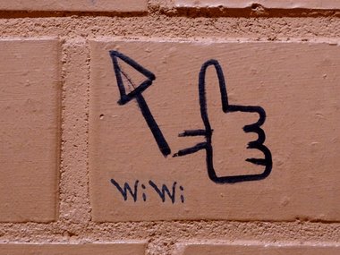 Die Abkürzung WiWi für Wirtschaftswissenschaften an einer Mauer mit einem Daumen-Hoch als Like-Zeichen.