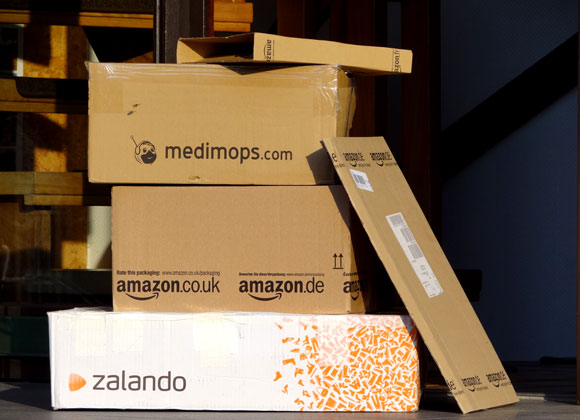Übereinander gestapelte Pakete der Online-Shops amazon, medimops und zalando.