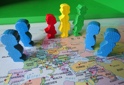 Das Bild zeigt eine Landkarte von Europa auf der in verschiedenen Ländern bunte Spielfiguren stehen.