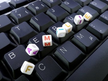Buchstaben und Computer-Tastatur bilden die Wörter Beruf und Familie 