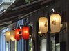 Lampions mit asiatischen Schriftzeichen in rot und weiß hängen vor einem Restaurant.
