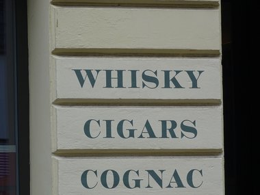 Ein weißes Schild mir dem Worten Whisky, Cigars und Congac.