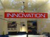 Ein roter Aufkleber auf einer Geschäftsscheibe eines Möbelladens mit der weißen Schrift: Innovation.
