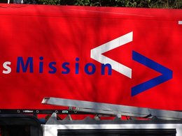 Der blaue Schriftzug: Mission auf einer roten Wand.