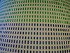 Ein Muster auf Stoff mit grünen und blauen Strichen auf hellem Grund.