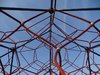 Das Netz eines Spielplatzklettergerüstes vor blauem Himmel.
