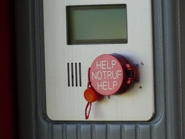 Ein roter Notrufknopf auf dem -Help-Notruf-Help- steht.
