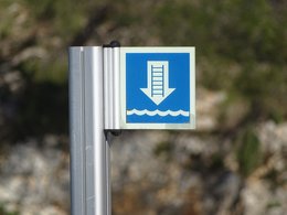 Ein kleines blaues Schild mit einem Pfeil nach unten, wobei auf dem Pfeil eine Leiter und darunter Wassser dargestellt ist.