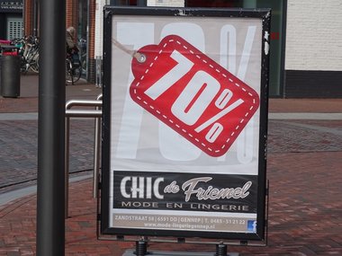 Ein Werbeschild in einer Fußgängerzone in rot für 70% Rabatt.