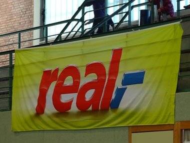 Banner von Real / Salvus Mineralwasser mit dem Slogan "Sportlich genießen"