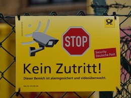 Ein gelbes Schild von der Post mit einem Stopzeichen, einer Kamera und den Worten: Kein Zutritt!