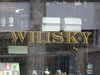 Ein Geschäftsfenster mit den Buchstaben für Whisky in gold auf der Scheibe.