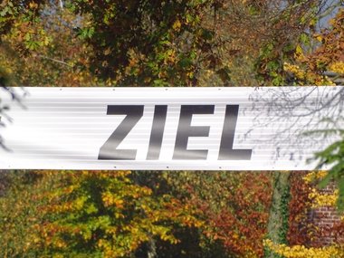 Weißes Startbanner auf dem in fetten schwarzen Buchstaben das Wort ZIEL steht.