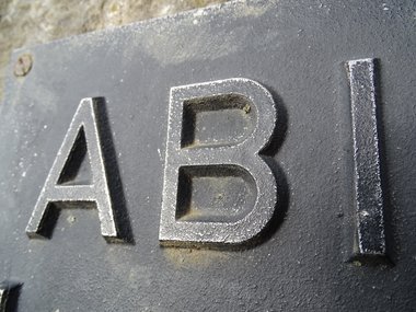 Das Schild mit den Buchstaben für ABI plastisch mit Metall dargestellt.