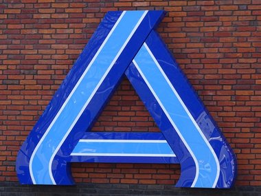 Das holländisch Aldizeichen - großes A- in hell und dunkelblau an einer roten Hausmauer.