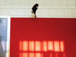 Bain-Karriereprogramm "Red Carpet": Von oben aufgenommen betritt eine Business-Frau gerade einen roten Teppich.