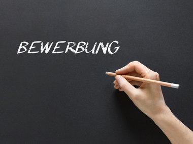 Das Wort BEWERBUNG auf einer Kreidetafel geschrieben.