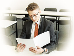 Ein Bewerber bereitet sich mit seiner Bewerbungsmappe auf sein Bewerbungsgespräch vor.