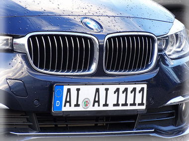 Das Bild zeigt Motorhaube und Kühlergrill eines dunkelblauen BMW.
