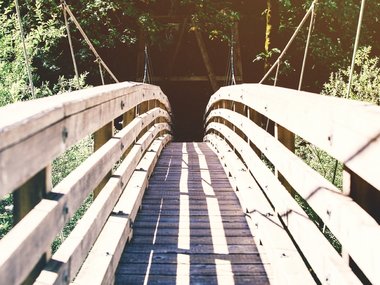 Eine rund geformte Holzbrücke.