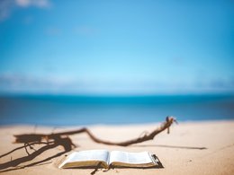 Ein Buch liegt im Sand am Strand.