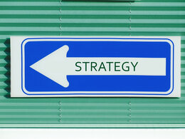 Ein blaues Schild mit der Aufschrift "Strategy" symbolisiert die neue Strategie im Change-Management.