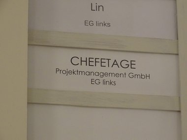 Eine Schild von der Chefetage, Projektmanagement GmbH, EG links.