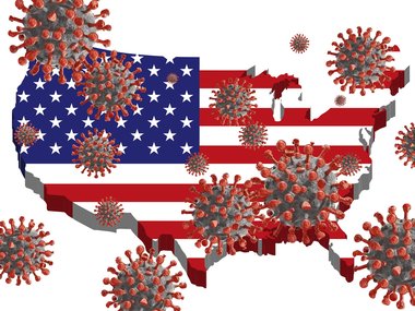 Das Bild zeigt die amerikanische Flagge im Format der Landkarte der Vereinigten Staaten von Amerika. Im Vordergrund sind zahlreiche Coronaviren zu sehen.