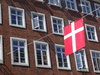 Dänemark: Vor einem Backsteinhaus in der Innenstadt von Aarhus hängt eine dänische Flagge.
